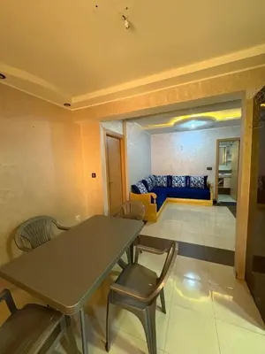 a living room with a table and chairs and a couch at Appartement 85m dans un quartier calme in Marrakech