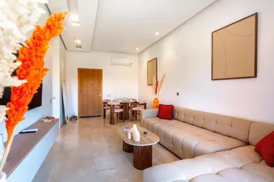 a living room with a couch and a table at Appartement de charme vue piscine et espace vert in Marrakech