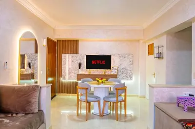 a living room with a table and chairs and a couch at Stylish Apartment in Gueliz by Train & Majorelle in Marrakech