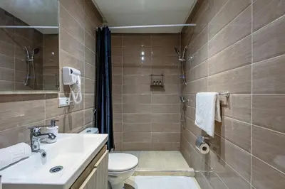a bathroom with a toilet and a sink and a shower at Stylish Apartment in Gueliz by Train & Majorelle in Marrakech