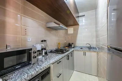 a small kitchen with a microwave and a stove at Stylish Apartment in Gueliz by Train & Majorelle in Marrakech