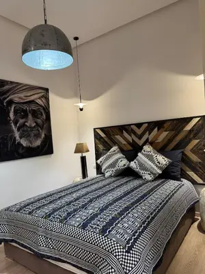 a bedroom with a large bed and a painting on the wall at Villa en centre Ville de Marrakech, 5 Chambres, Piscine, Rooftop in Marrakech