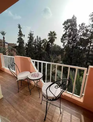a balcony with two chairs and a table at Blue Majorelle in Marrakech