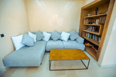 a living room with a blue couch and a coffee table at Appartement XXL résidence privée piscine Dar Dmana PALMERAIE in Marrakech