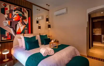 a bedroom with two beds with a painting on the wall at Suite Ultra Deluxe, Babylone, Ultra Confort, Hyper-Centre, Marrakesh in Marrakech