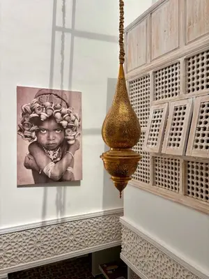 a picture of a child on a wall next to a painting at Riad MONA Marrakech Kasbah Médina in Marrakech
