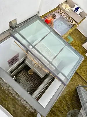an overhead view of a glass house with a woman in it at Riad MONA Marrakech Kasbah Médina in Marrakech