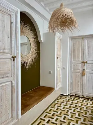 a hallway with a mirror and a room with doors at Riad MONA Marrakech Kasbah Médina in Marrakech