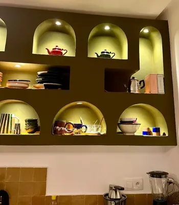 a kitchen with green shelves with dishes on them at Riad MONA Marrakech Kasbah Médina in Marrakech