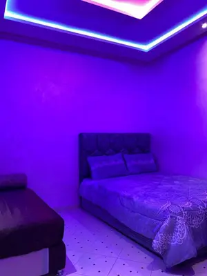 a purple room with a bed and a couch at AJ Apartment Ideal for Families, Married Couples, and Solo Travelers in Marrakech