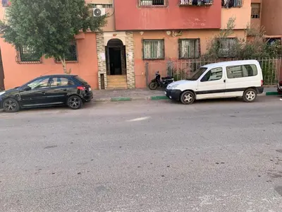 two cars parked in front of a building at AJ Apartment Ideal for Families, Married Couples, and Solo Travelers in Marrakech