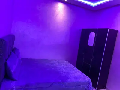 a bedroom with a purple room with a bed and a cabinet at AJ Apartment Ideal for Families, Married Couples, and Solo Travelers in Marrakech