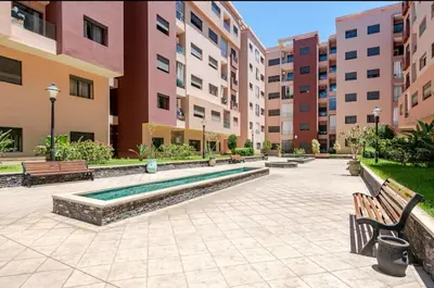 a courtyard with benches and a swimming pool in a building at Beautiful accommodation with 2 pools & fast WiFi in Marrakech