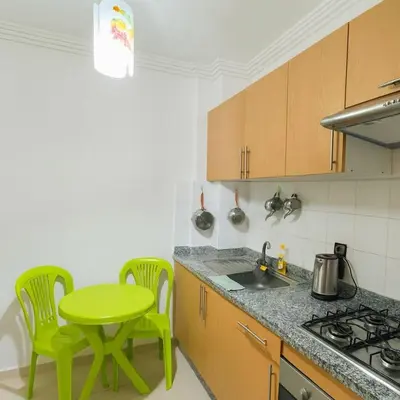a kitchen with a green table and chairs in it at NS 53 by KMREI Properties in Marrakech
