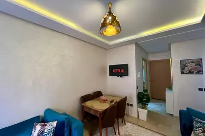 a dining room with a table and a clock on the wall at NS 53 by KMREI Properties in Marrakech