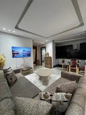 a living room with a couch and a tv at Garden level & pool, cozy apartment queen size bed in Marrakech