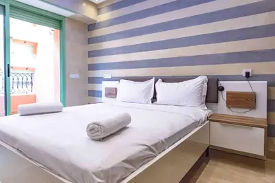 a bedroom with a large white bed with a striped wall at Appartement Confort - Hivernage - Piscine in Marrakech