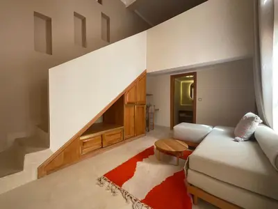 a living room with a white couch and a red rug at Riad Al Muhandiz Peaceful Duplex Suites near Jemaa El Fna in Marrakech