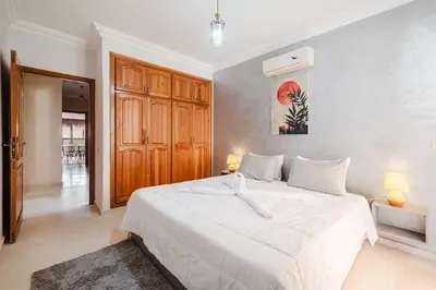 a bedroom with a large white bed with two lamps at apartment gilez in Marrakech