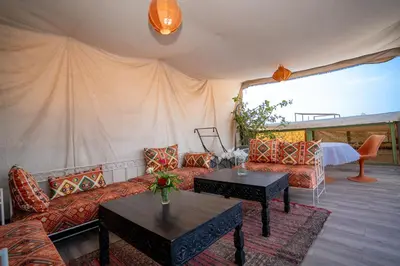 a living room with a couch and tables and a tent at Dar JOMANA in Marrakech