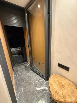 a bathroom with a glass shower with a wooden stool at Elite studio 17 in Marrakech