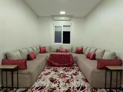 a living room with a large couch with red pillows at Appartement meublé à louer à Marrakech in Marrakech