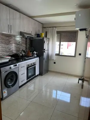 a kitchen with a stove and a refrigerator at Appartement familial moderne et cosy in Marrakech