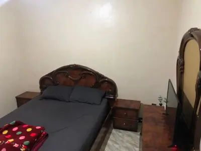 a bed with a wooden headboard in a bedroom at ÉTABLISSEMeNT BEAU SÉJOUR in Marrakech