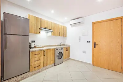 a kitchen with a stainless steel refrigerator and wooden cabinets at Modern & cozy apartment in Marrakech