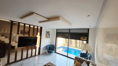 a living room with a tv and a swimming pool at Villa with private pool in Marrakech