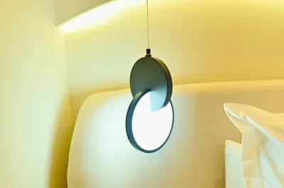 a circular pendant light hanging from a wall at Luxurious colorful apartment in Marrakech