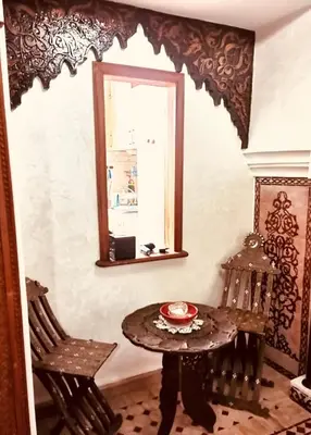 a room with a table and two chairs and a mirror at Air Conditioned Appartment across YSL Museum in Marrakech