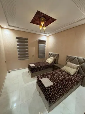 a room with two beds and a ceiling fan at Villa avec piscine privé in Marrakech
