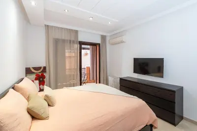 a bedroom with a large bed with a television on the wall at La Perle - Semlalia Gueliz - 2 Prs - Balcony in Marrakech