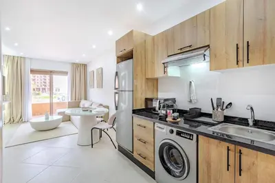 a kitchen with a sink and a washing machine at Appartement chic près de la gare in Marrakech