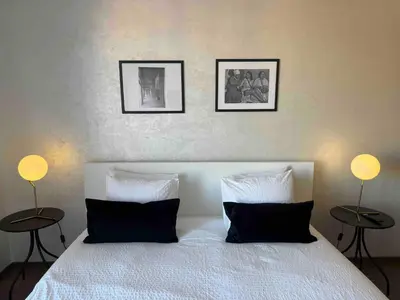 a bedroom with a white bed with two tables at TERRASSE, 2 CHAMBRES SPACIEUSES, 6 COUCHAGES, 2 PiSCINES, PARKING, IDÈAL FAMILLE in Marrakech