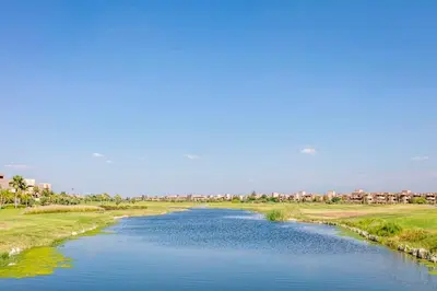 a view of a river with houses in the background at RESIDENCE PRESTIGIA, Piscine, calme et verdure in Marrakech
