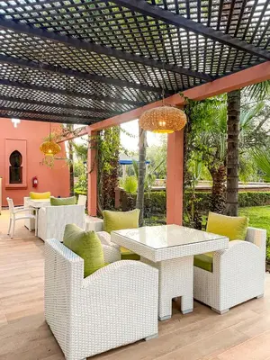 a patio with a white table and chairs at Complexe villa and Restaurant in Marrakech
