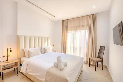 a white bedroom with a large bed and a chair at Nouvel 1 chambre proche centre in Marrakech