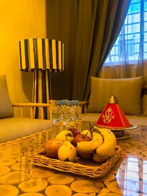 a basket of fruit on a table with a lamp at A flat near the airport in Marrakech
