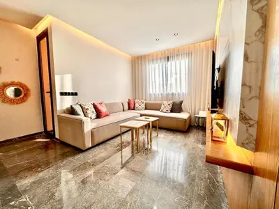 a living room with a couch and a table at Cozy and Spacious Apartment, Free Parking in Marrakech