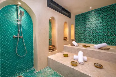 a bathroom with a shower with green tiles at Villa Anzar Refined Oasis wChef and Emerald Hammam in El Rhechat