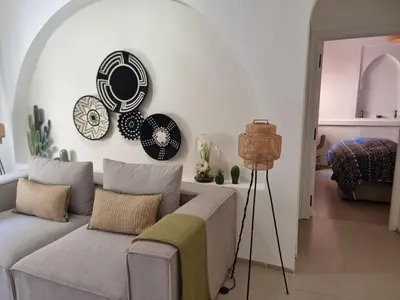 a living room with a couch and plates on the wall at Bohemian & Moroccan Apartment Close to Airport & Medina in Marrakech