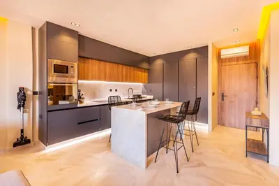 a kitchen with a counter and chairs in a room at Apartment with swimming pool in Marrakech