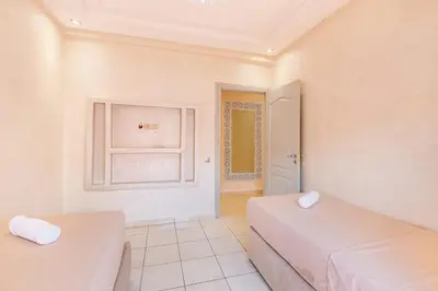 a room with two beds and a window at 2 chambres dans la ville rouge in Douar Bellouk