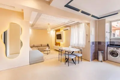 a living room with a table and a couch at 2 chambres dans la ville rouge in Douar Bellouk