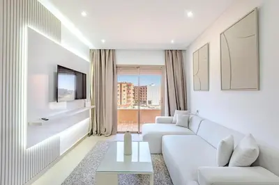 a living room with white furniture and a large window at Escapade intime en ville rouge in Marrakech
