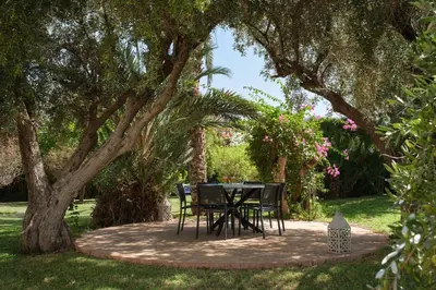 a table and chairs sitting under a tree at Villa Monica in Marrakech