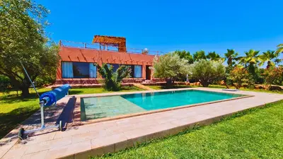 a swimming pool in front of a house at Villa Deneb - secret garden, swimming pool and starry sky in Marrakech