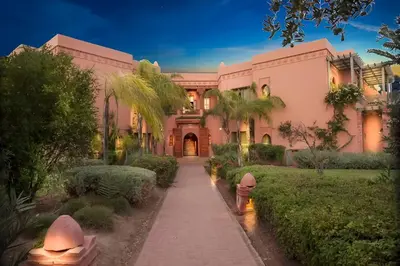 a pink building with a fire hydrant in front of it at La perle de la palmeraie in Marrakech
